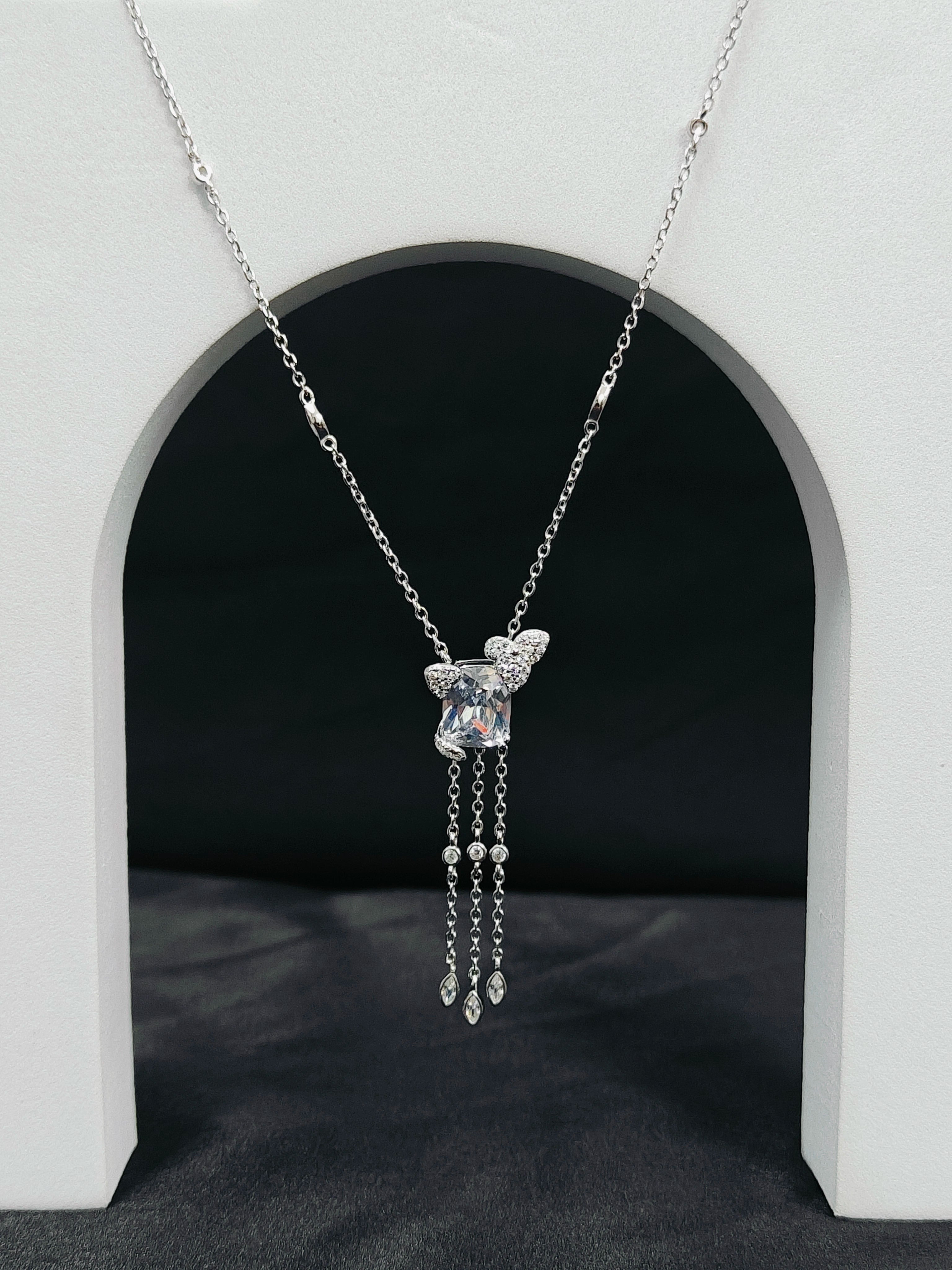 Silver necklace with a pendant on a black background